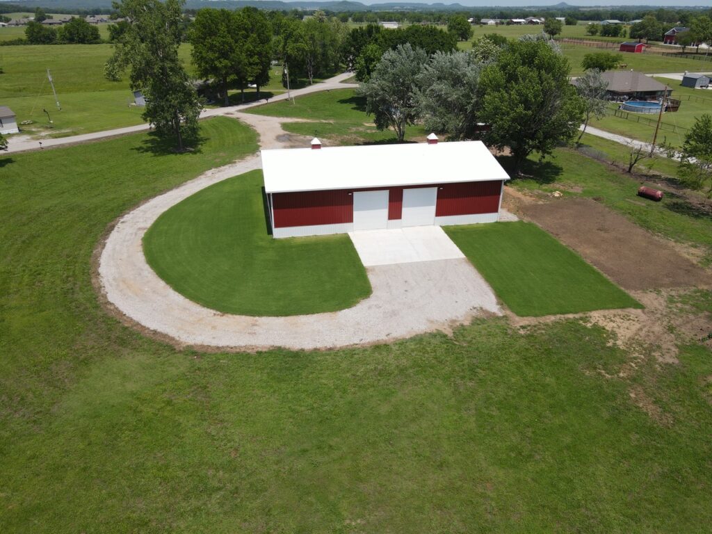 Crimson Buildings Latest Projects SIDE VIEW OF A RED POLEBARN WITH ROCK DRIVE