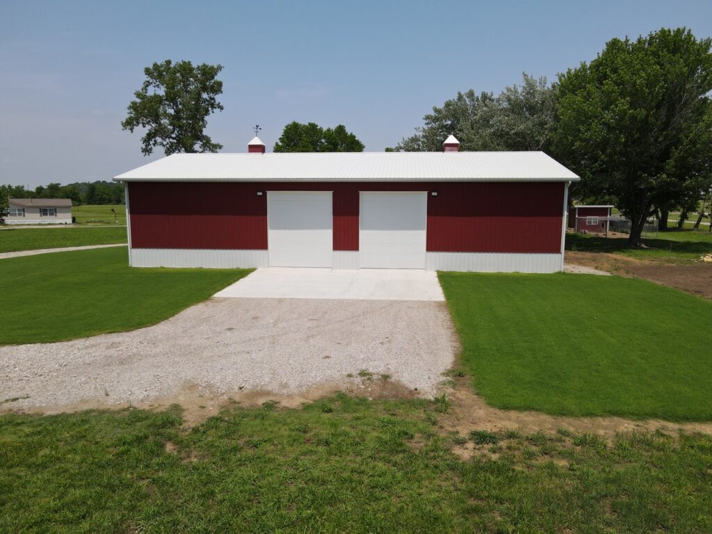Crimson Buildings FRONT VIEW OF A RED POLEBARN WITH ROCK DRIVE