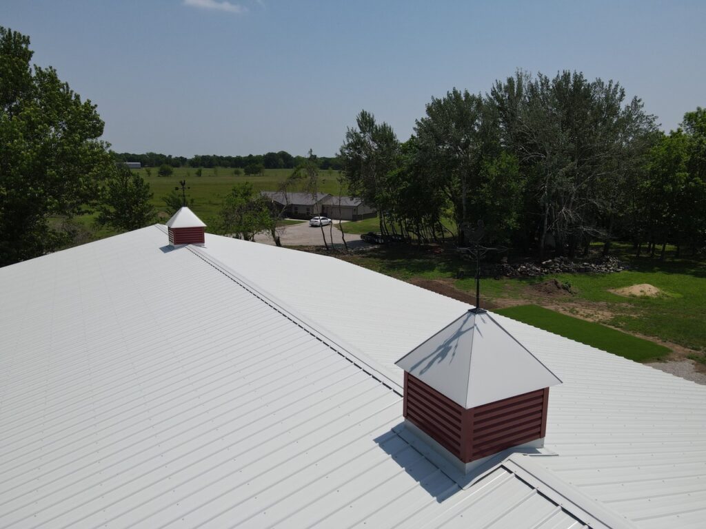 Crimson Buildings This is an image of a metal building built by Crimson Buildings. We are located in Inola, Ok and service the surrounding areas. AERIAL VIEW OF CUPOLAS ON A POLE BARN